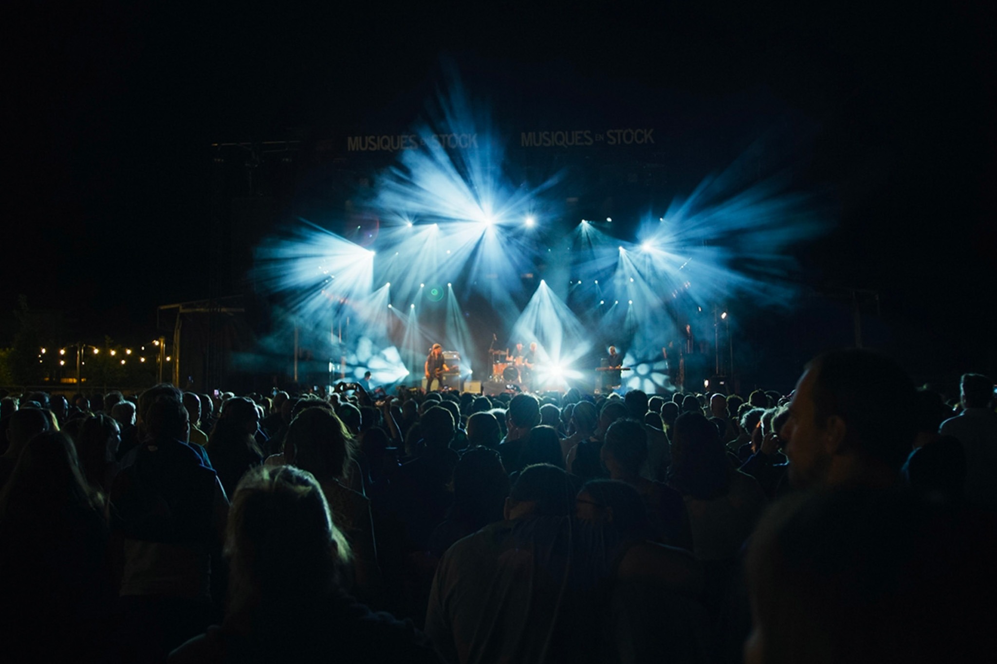 Musiques en Stock festival : vue d'un concert sur scène, de nuit, public de festivaliers au premier plan.